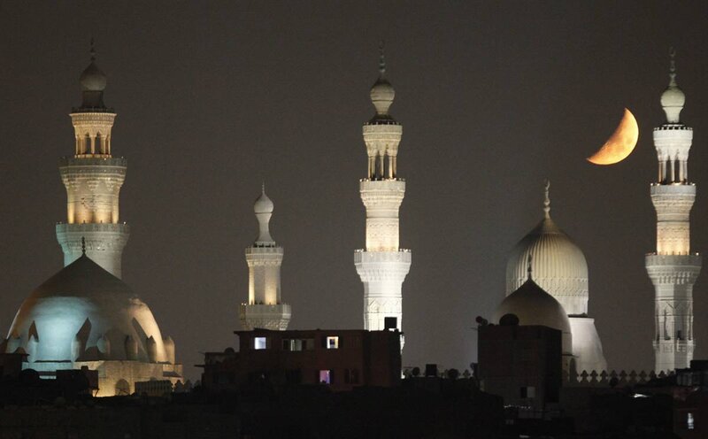 Moon over mosque minarets