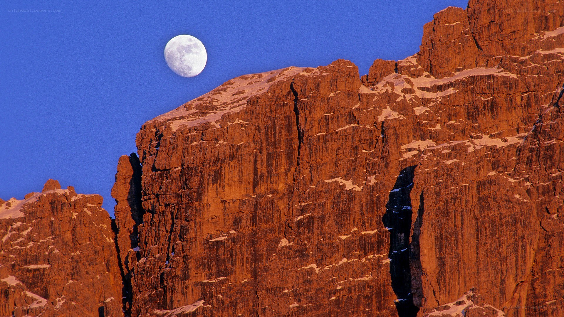 Moon over mountain cliffs