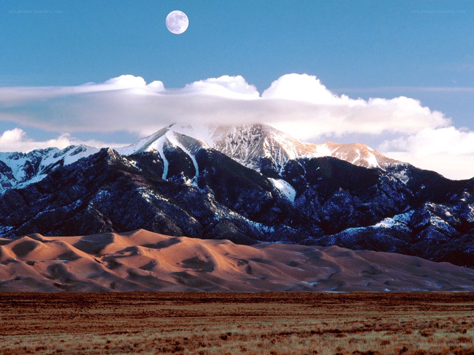 Moon over mountains and dunes