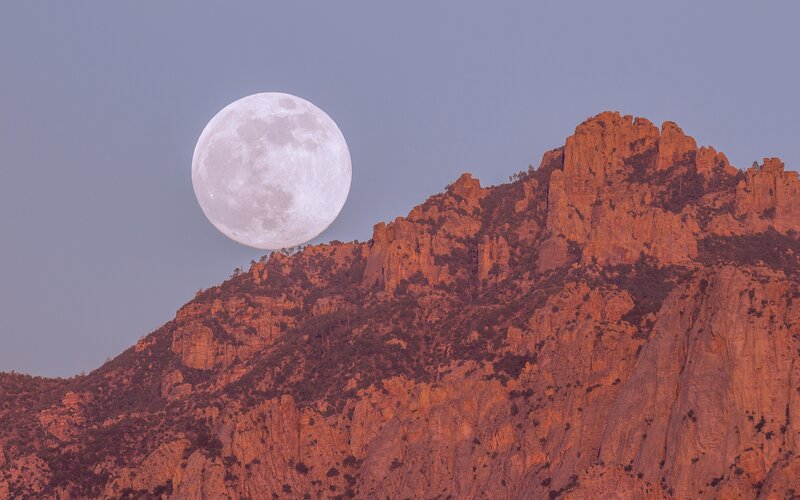 Moon over red rock cliffs