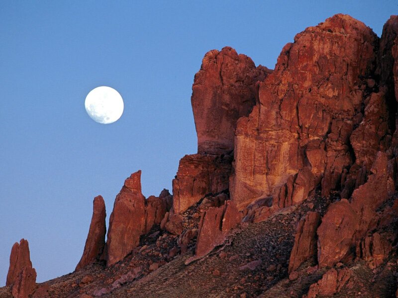 Moon over red rock formations