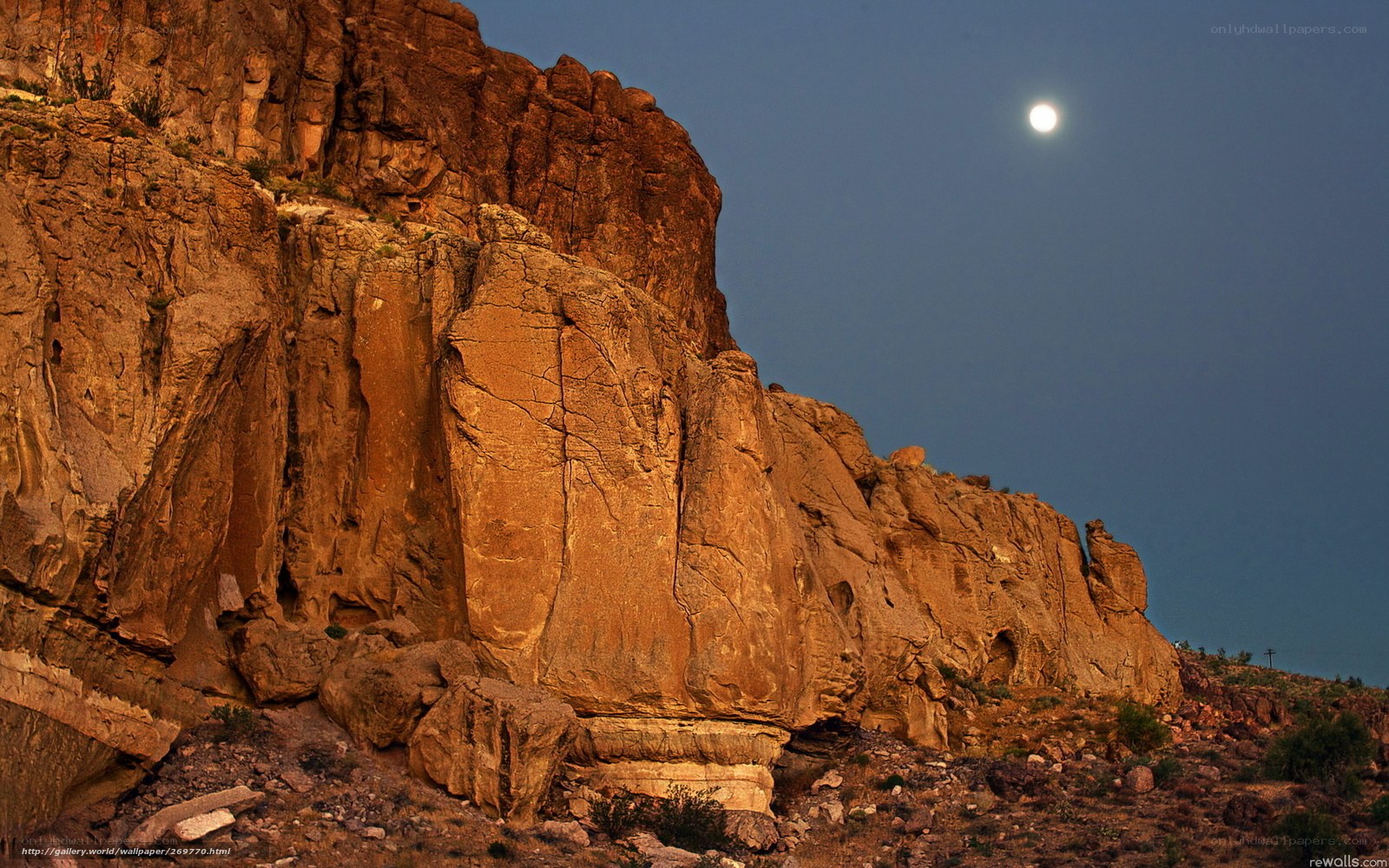 Moon over rocky cliff