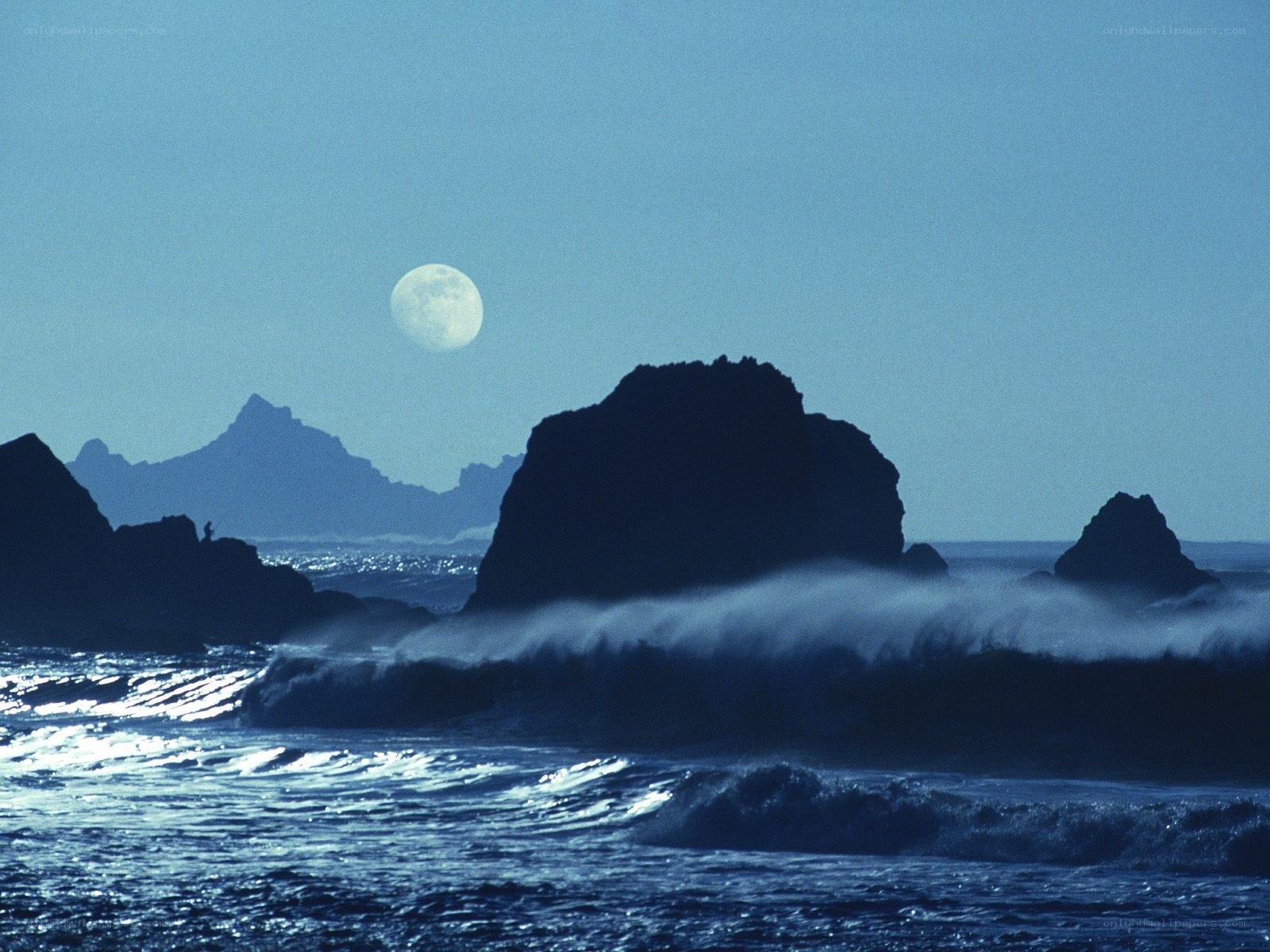 Moon over rocky coastline