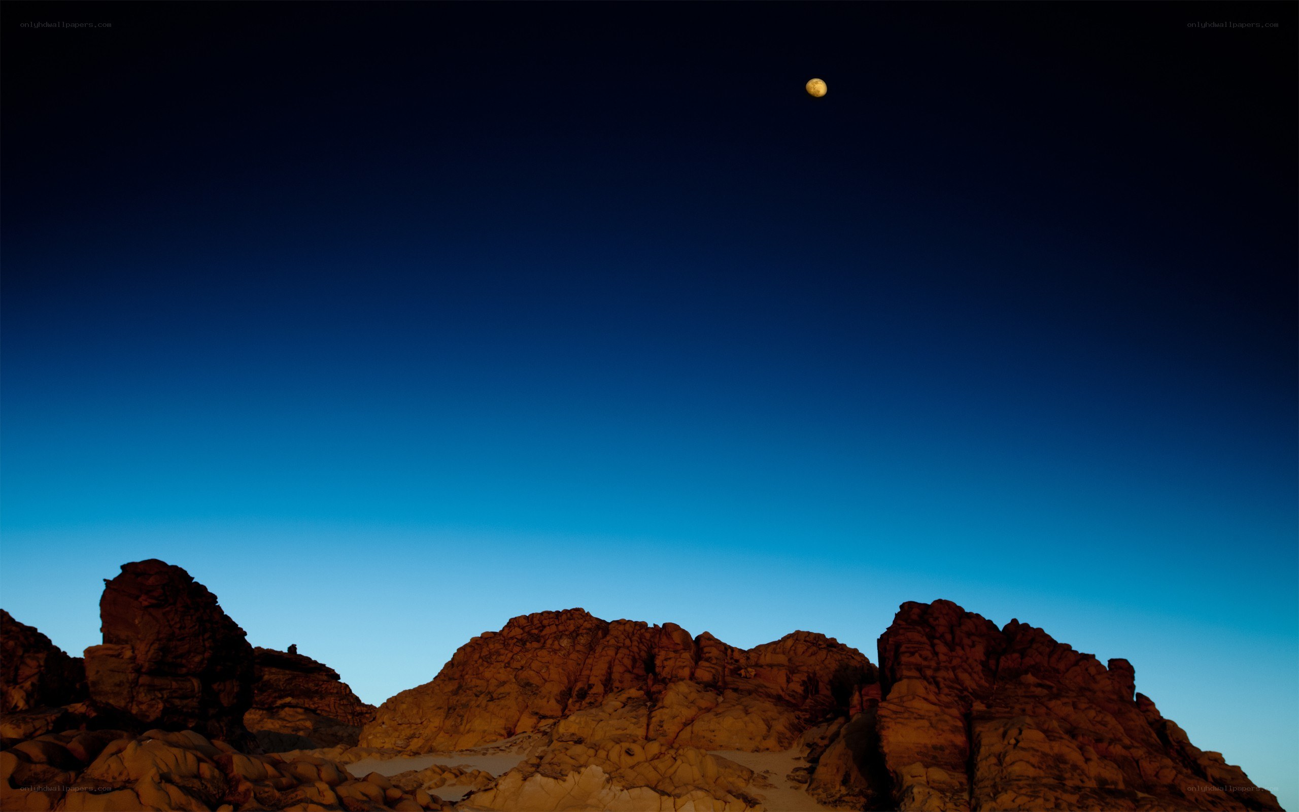 Moon over rocky landscape