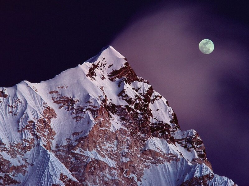 Moon over snow-capped mountain