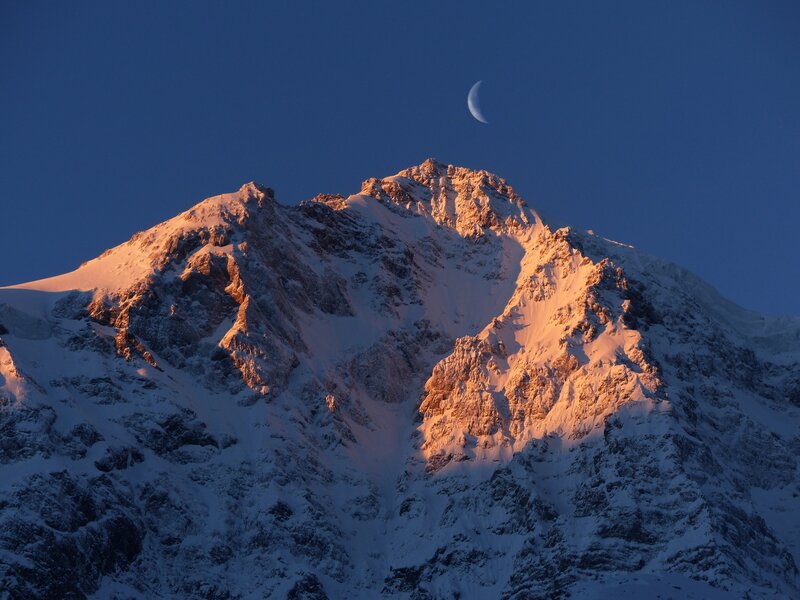 Moon over snow-capped mountain