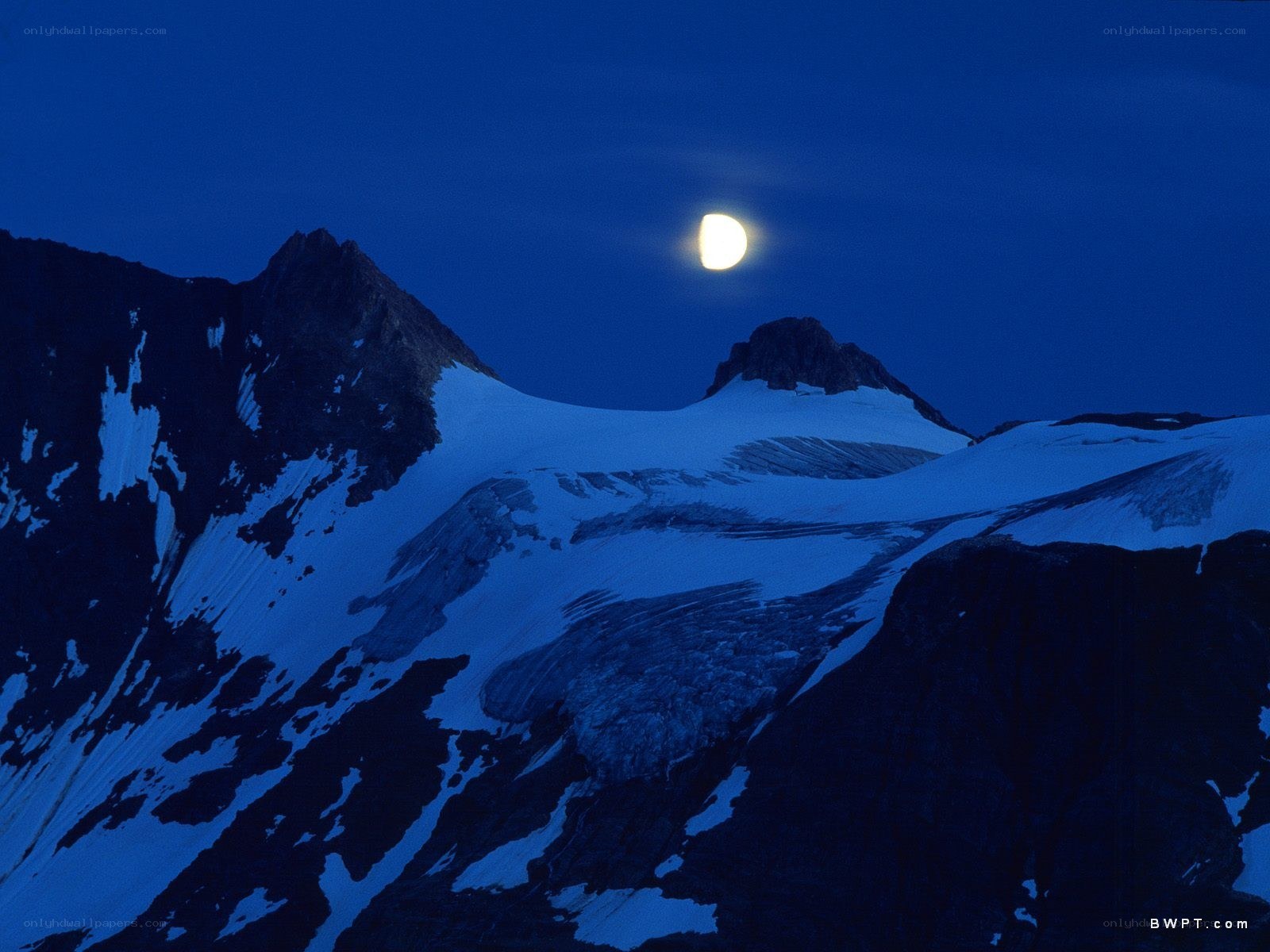 Moon over snow-capped mountains