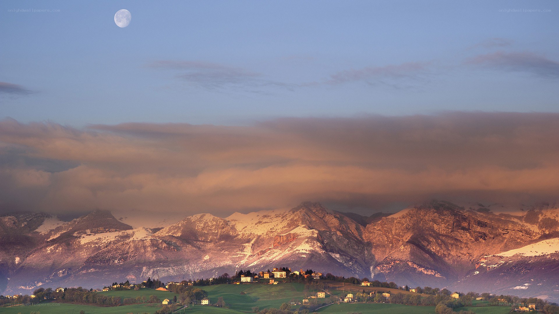 Moon over snow-capped mountains