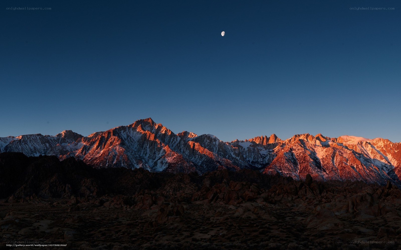 Moon over snow-capped mountains