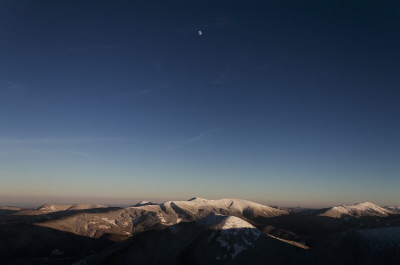 Moon over snow-capped mountains