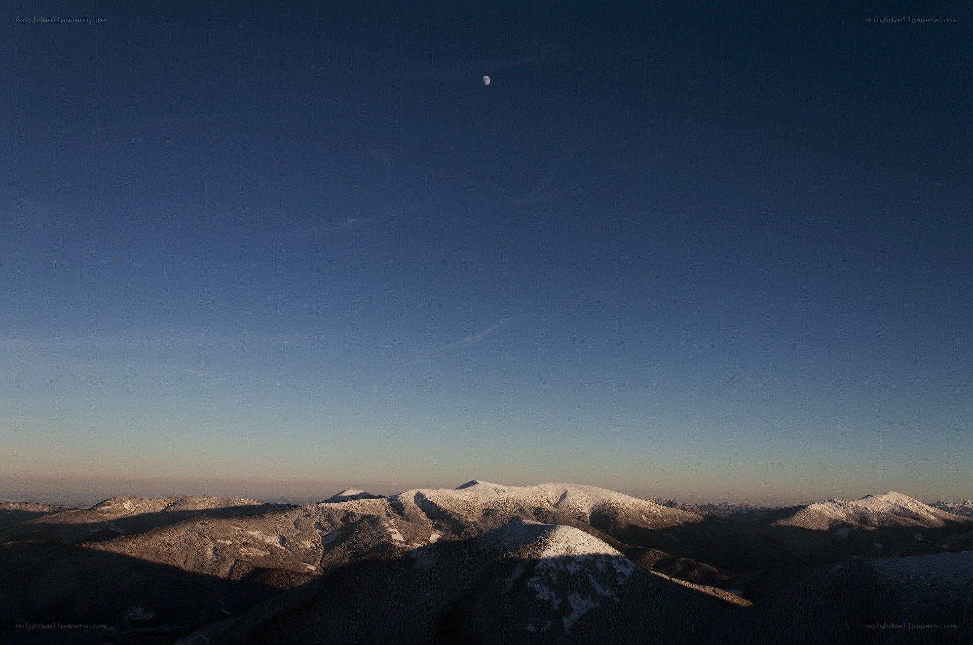 Moon over snow-capped mountains