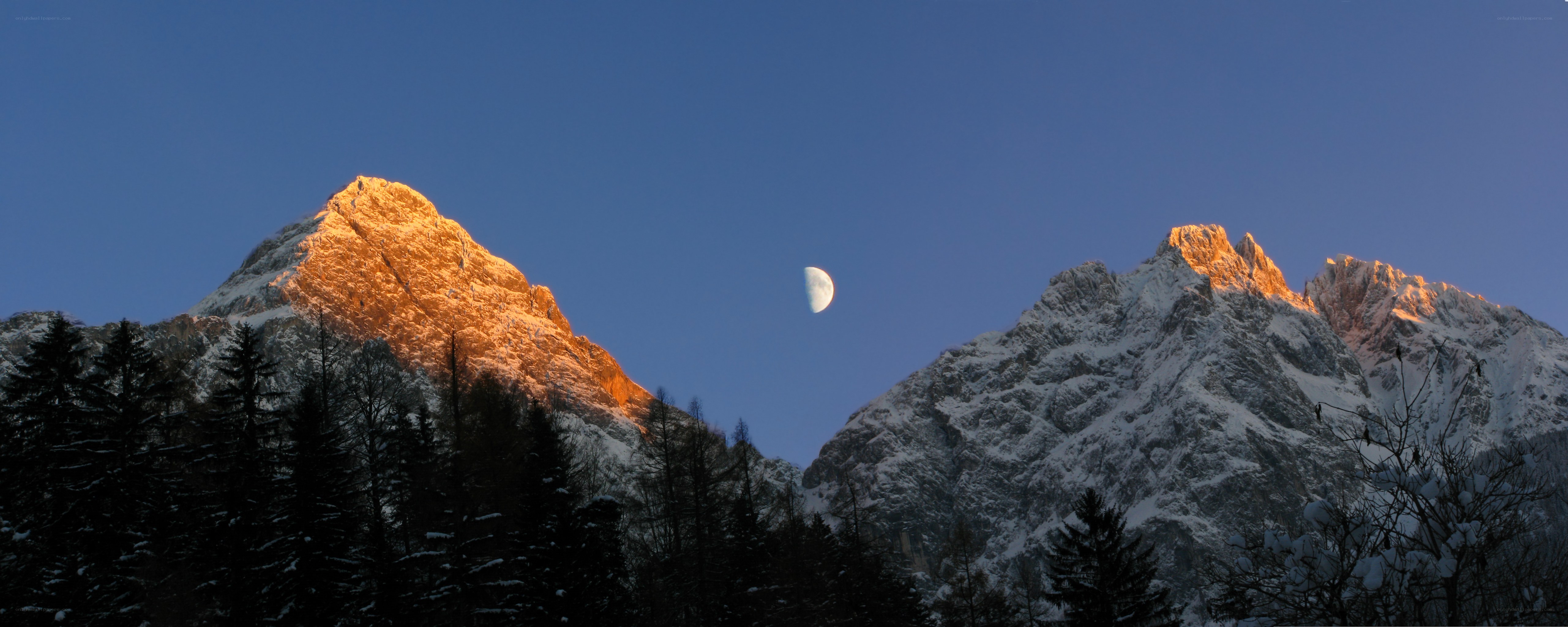 Moon over snow-capped mountains