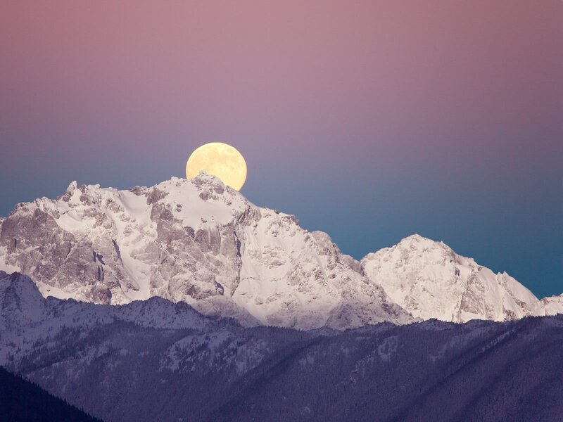 Moon over snow-capped mountains