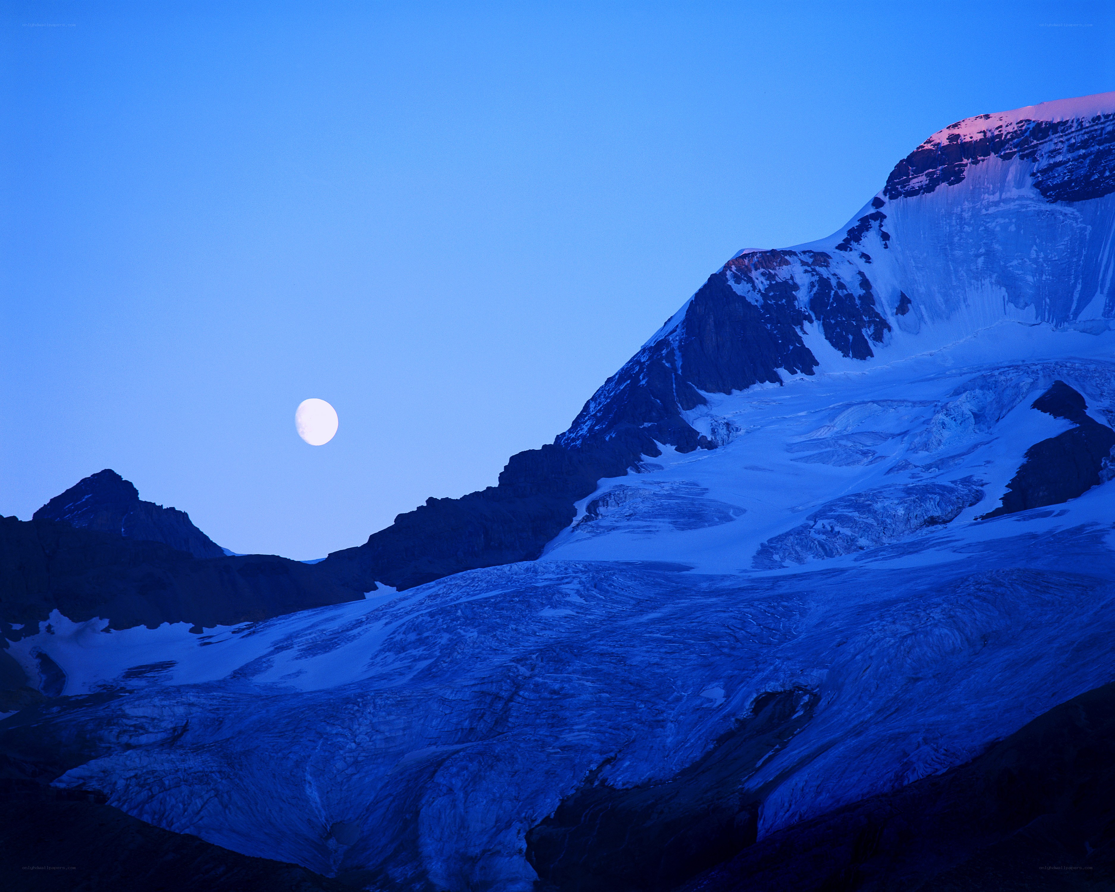 Moon over snowy mountain