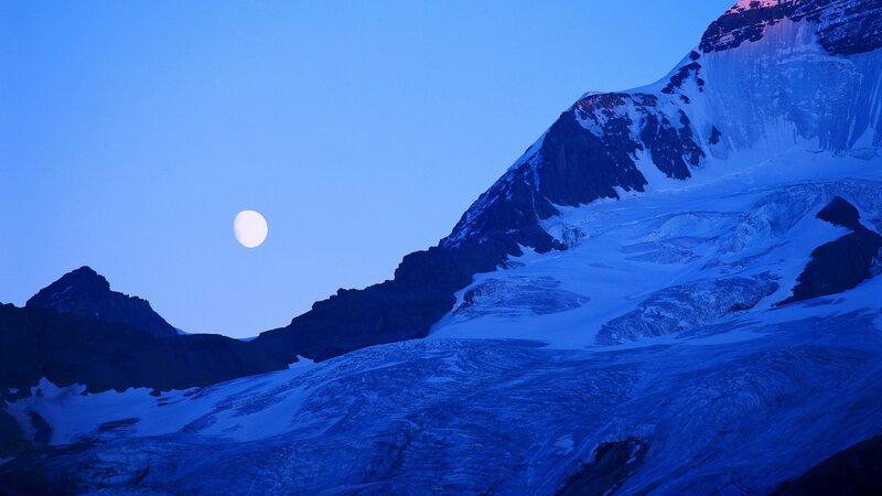 Moon over snowy mountain