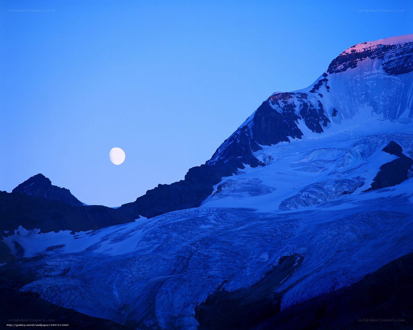 Moon over snowy mountains