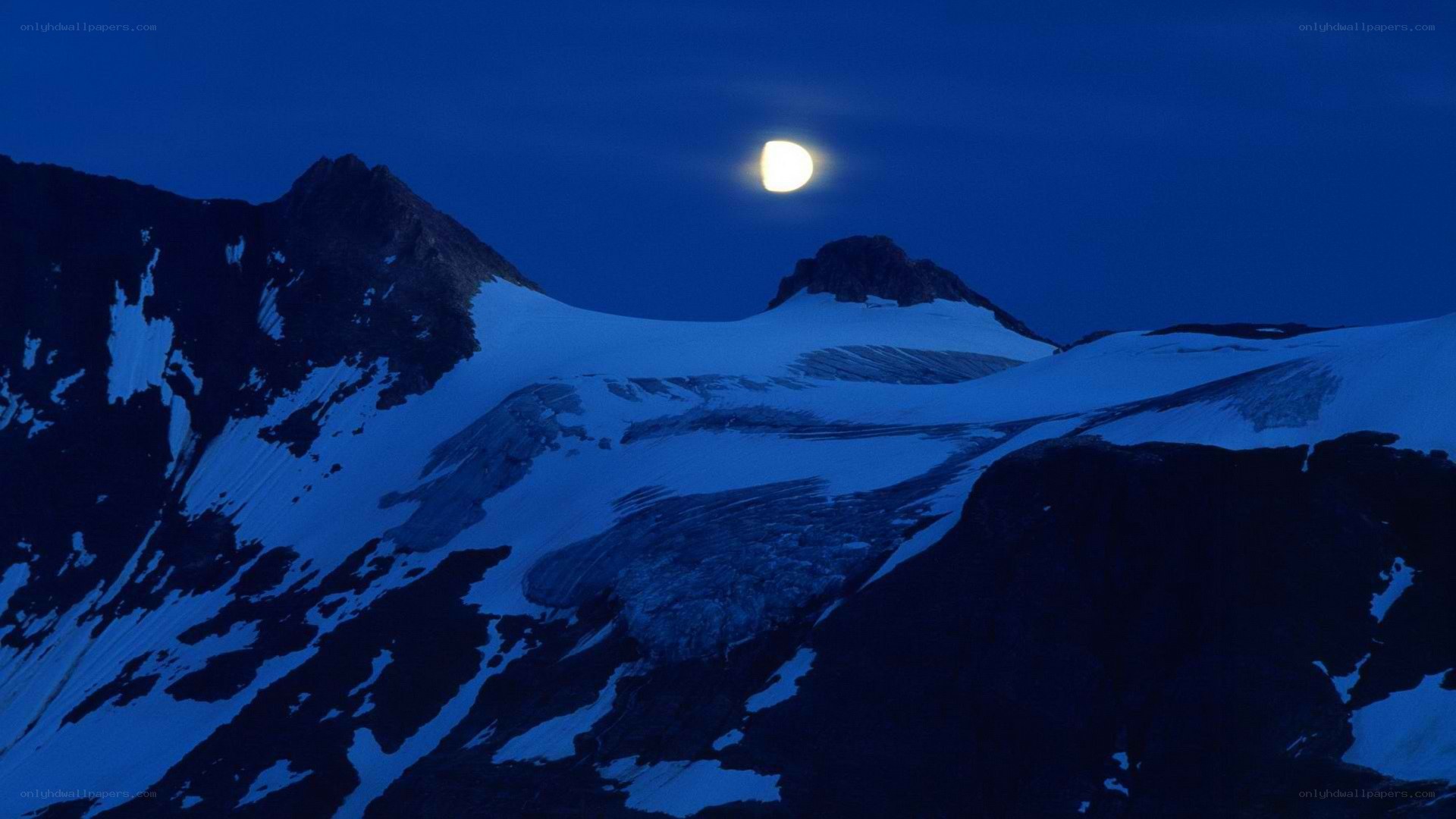 Moon over snowy mountains
