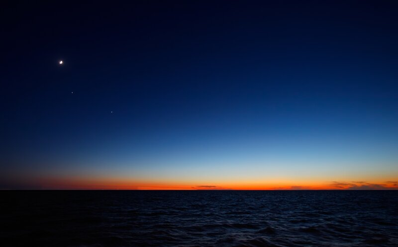Moon over the ocean at dusk