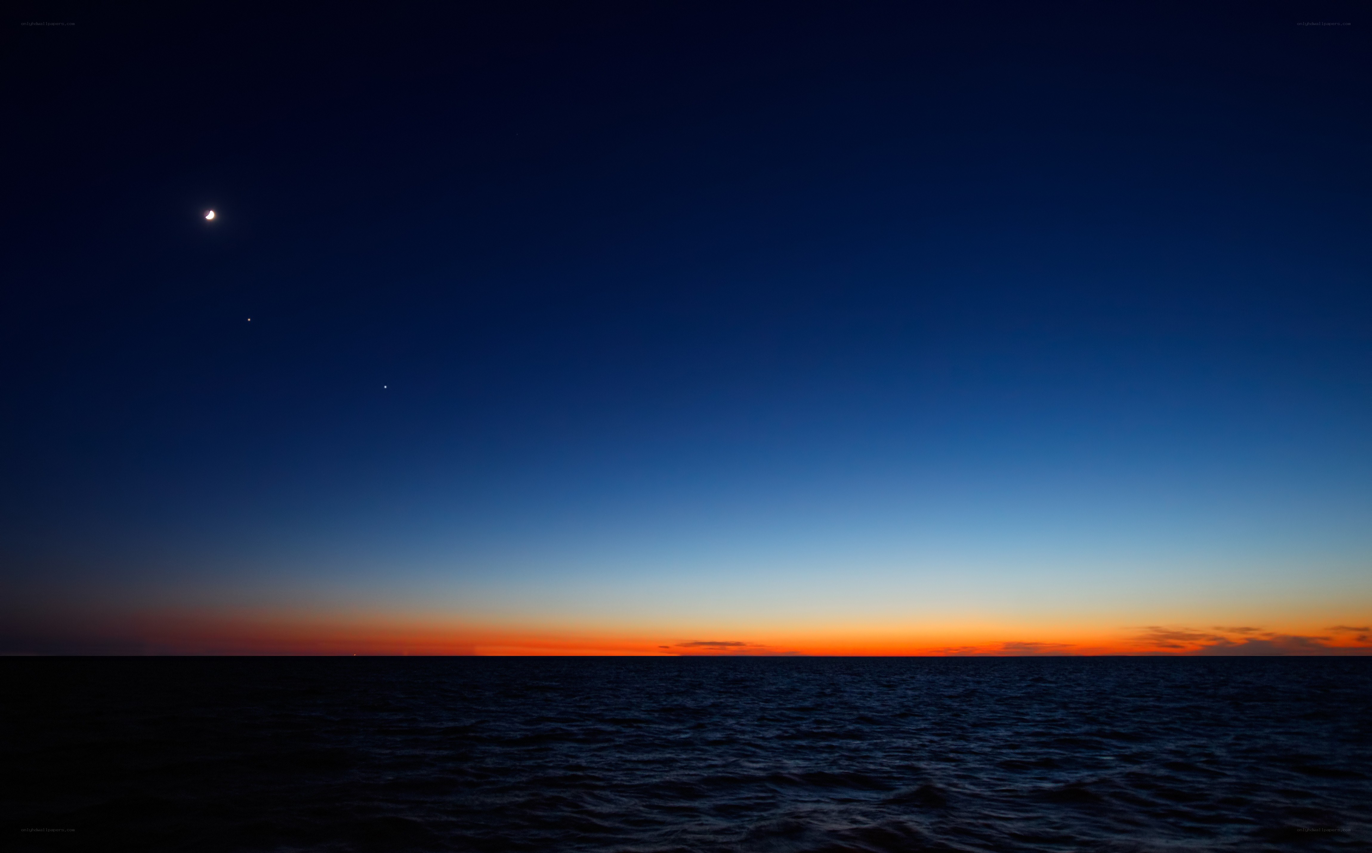 Moon over the ocean at dusk