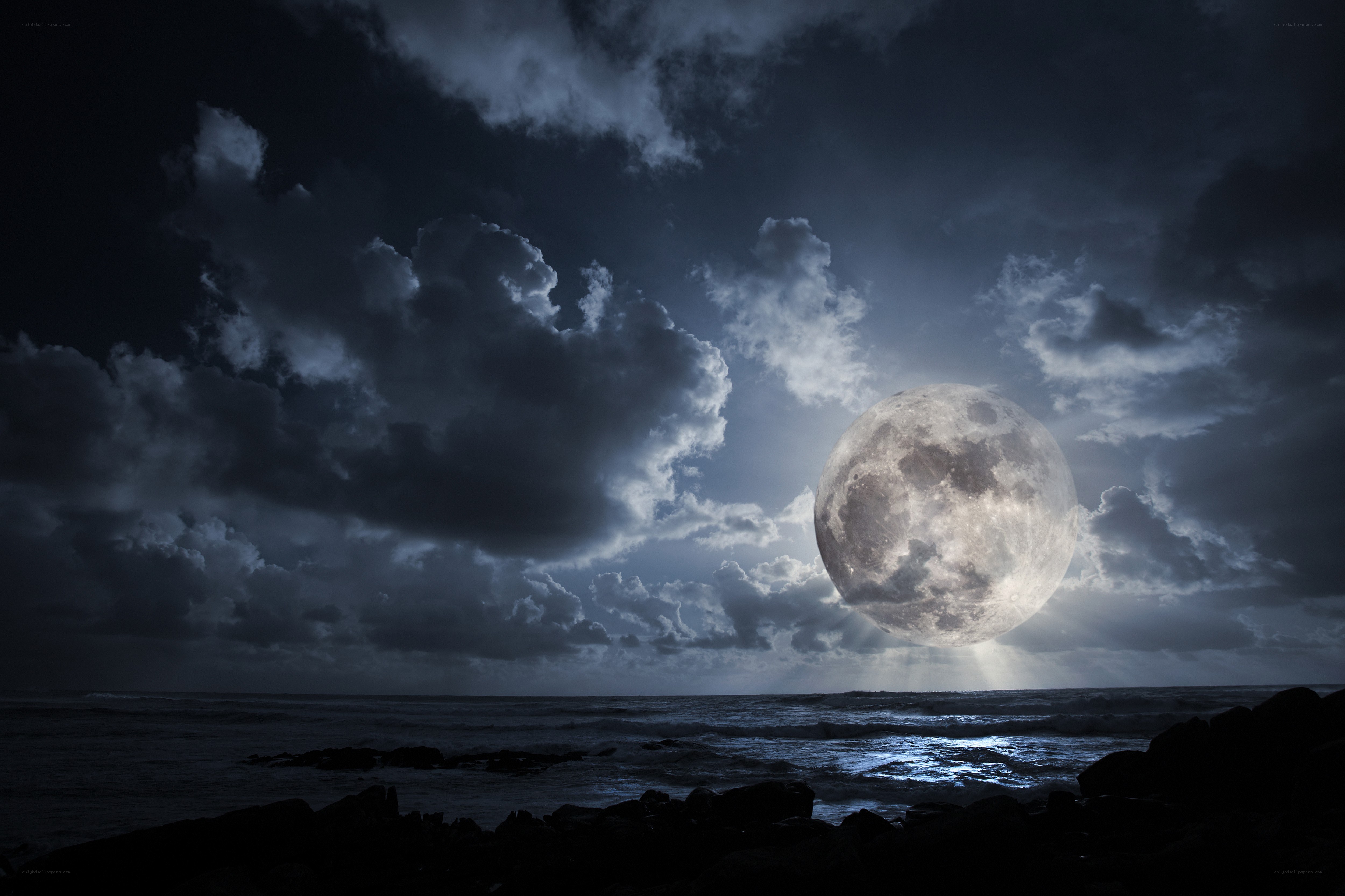Moon over the ocean at night
