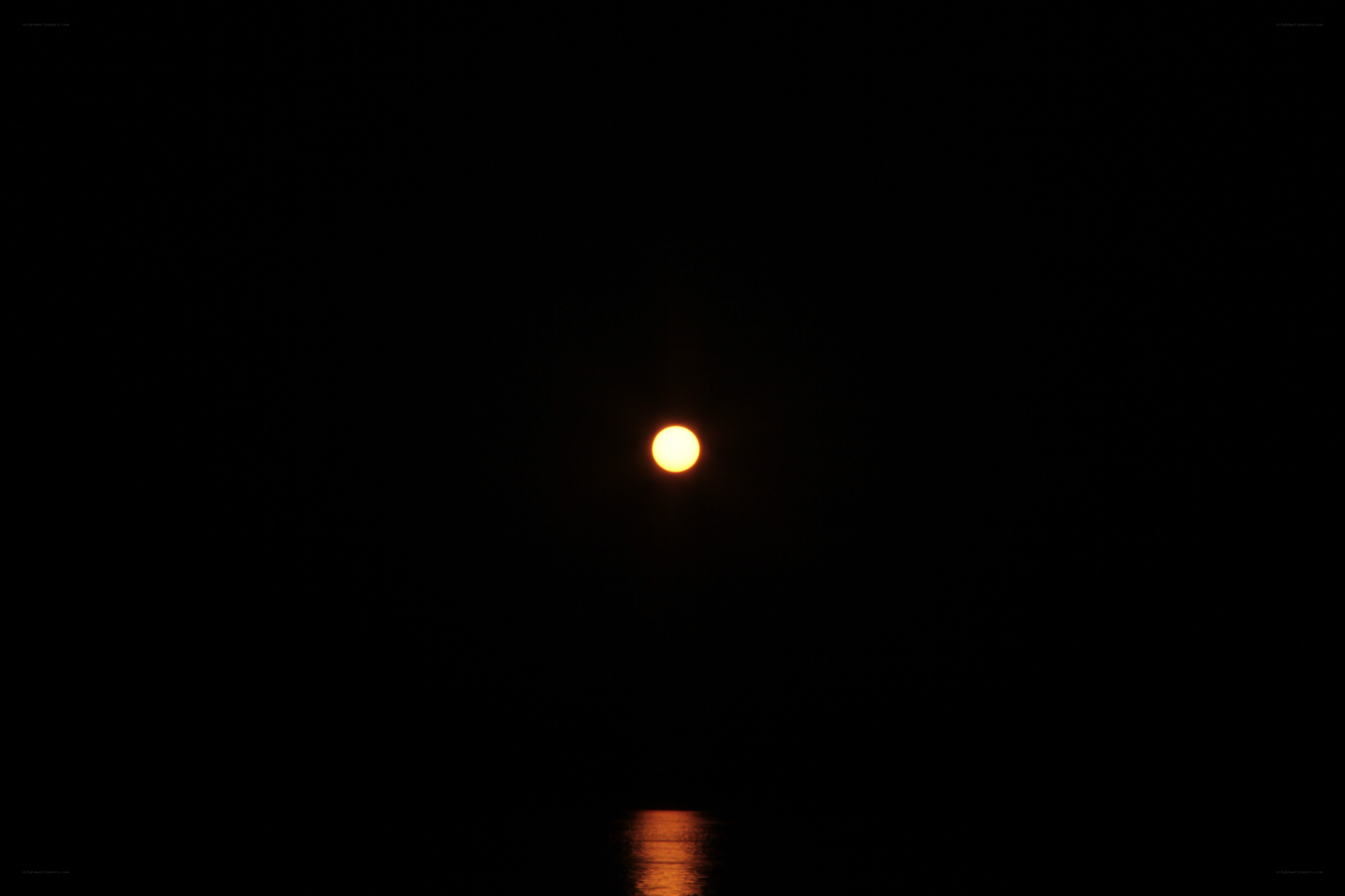 Moon over water at night
