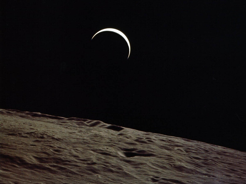 Moon surface with crescent Earth