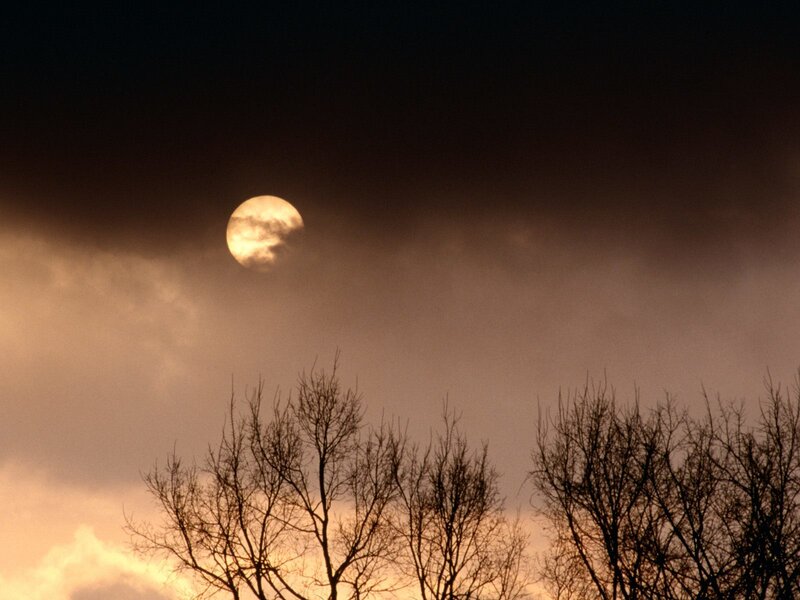 Moon through clouds at dusk