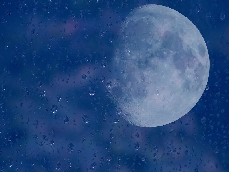 Moon through rain-streaked window
