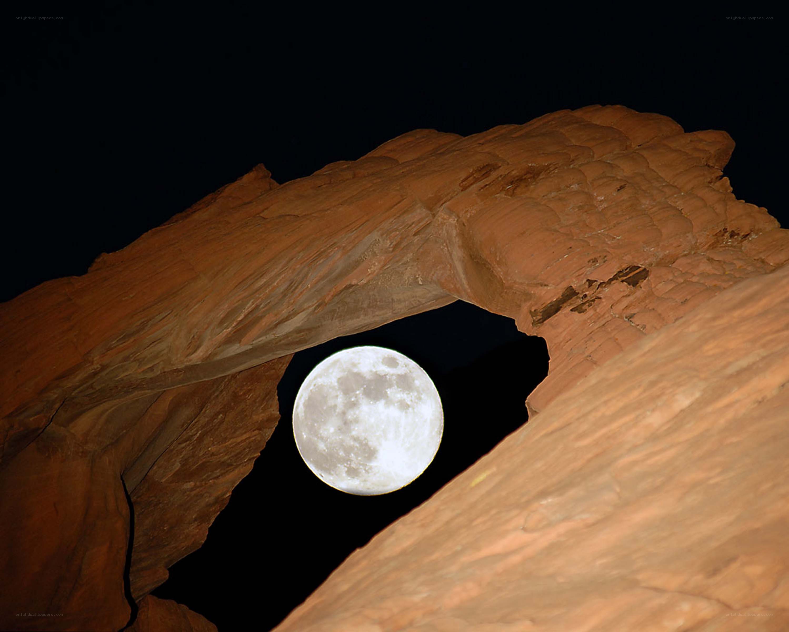 Moon through rock arch