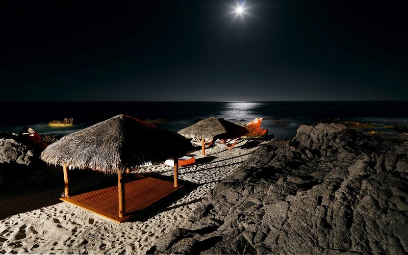 Moonlit beach huts at night