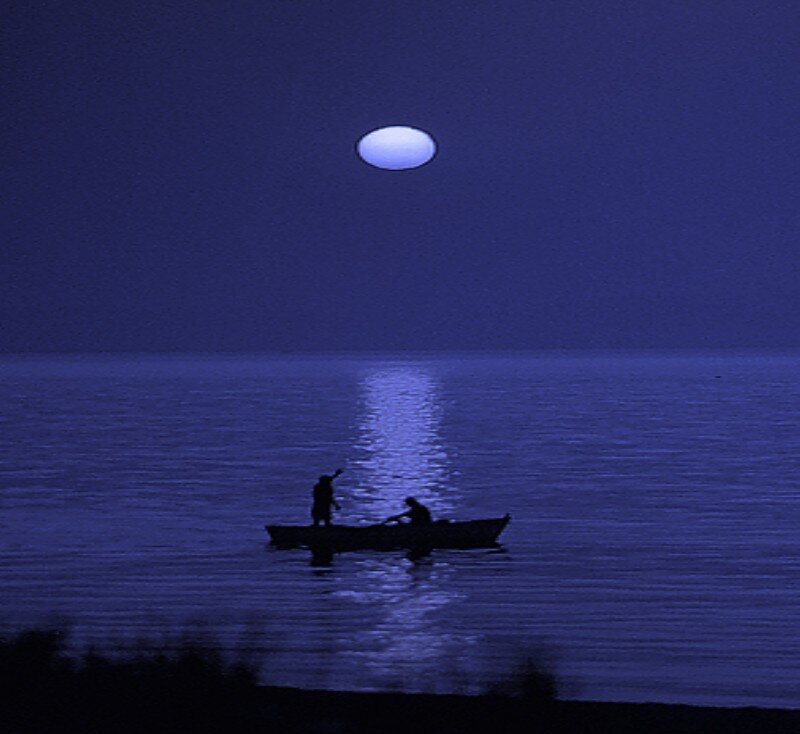 Moonlit boat on calm water
