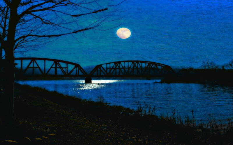 Moonlit bridge over river