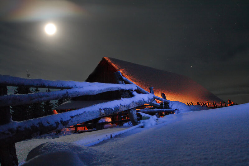 Moonlit cabin in snow