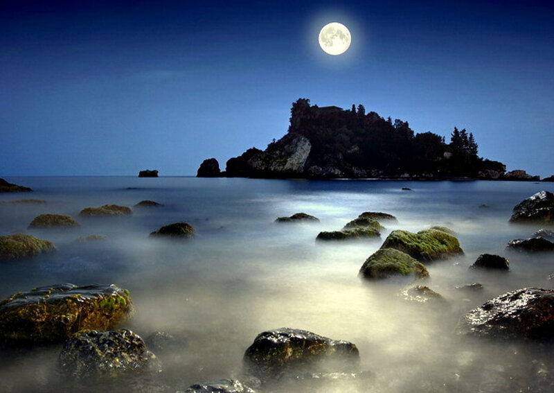 Moonlit coastal island at night