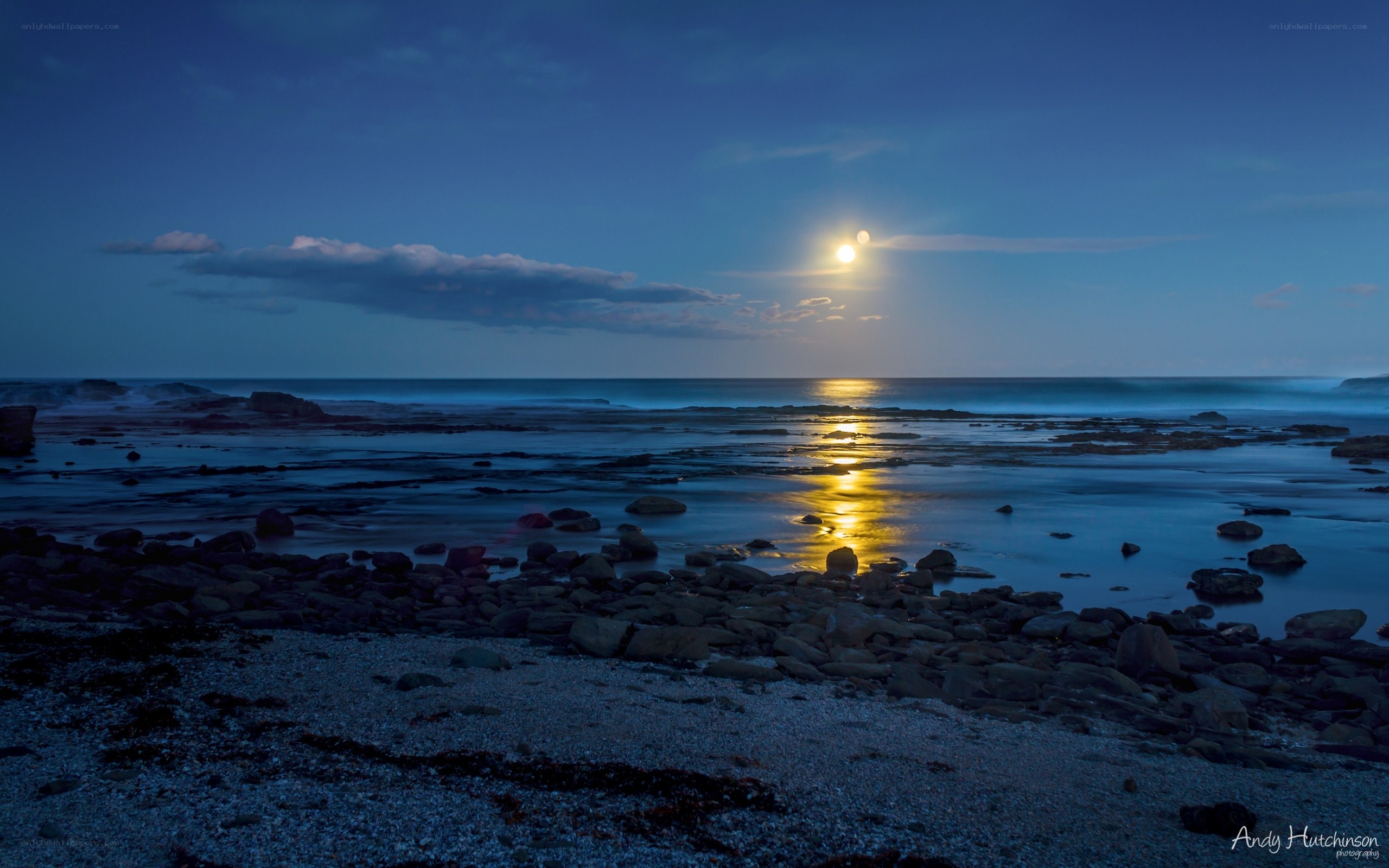 Moonlit coastal rocks at dusk