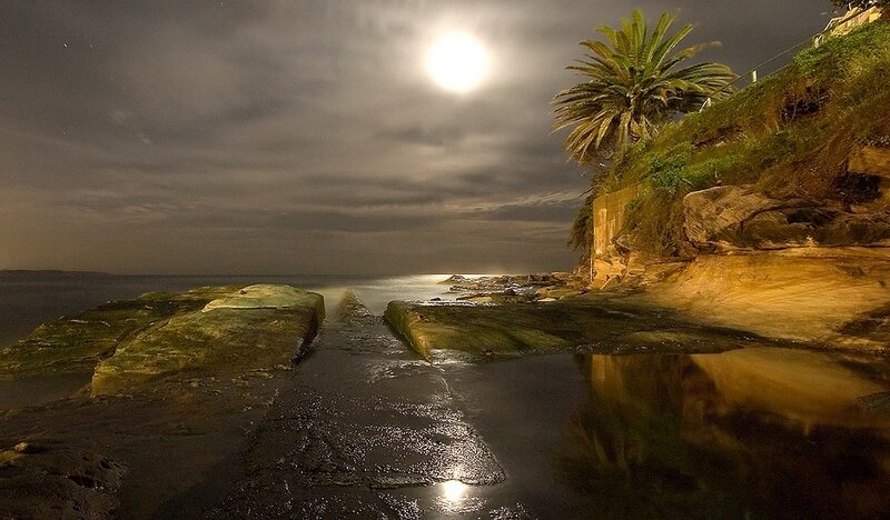 Moonlit coastal rocks at night