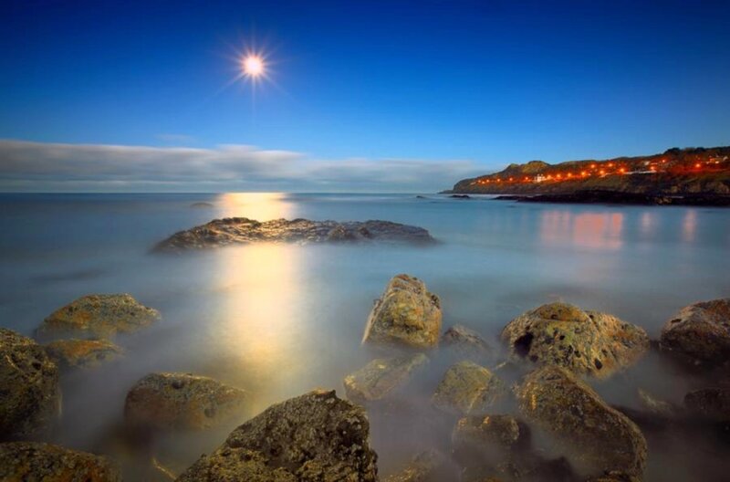 Moonlit coastal rocks at night