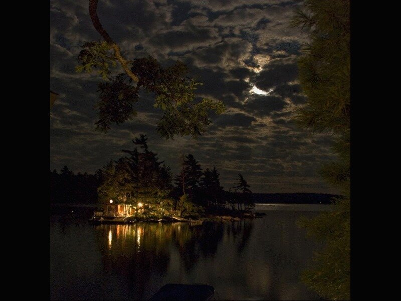 Moonlit lake cabin at night