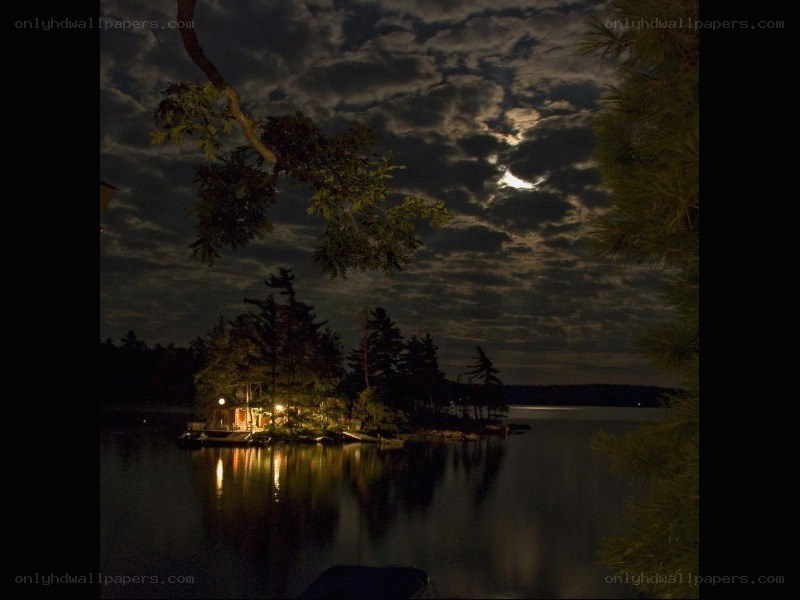 Moonlit lake cabin at night