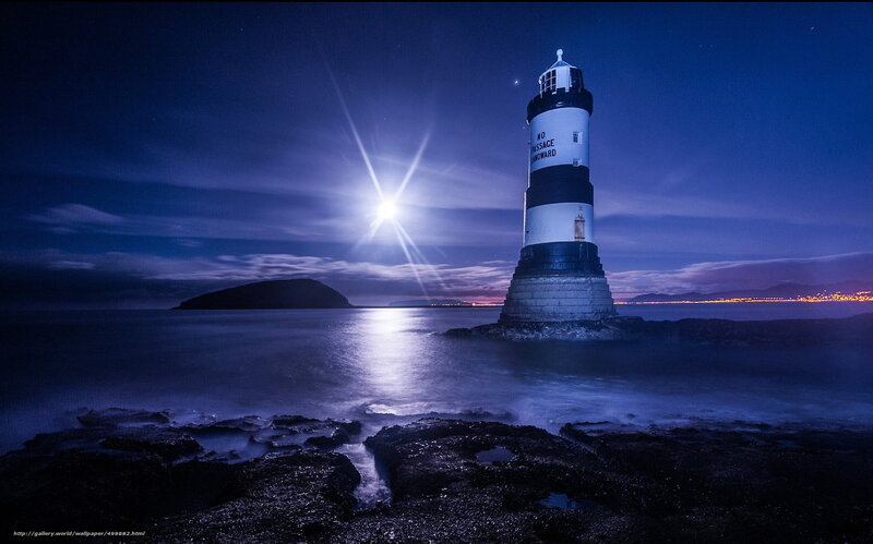 Moonlit lighthouse at night