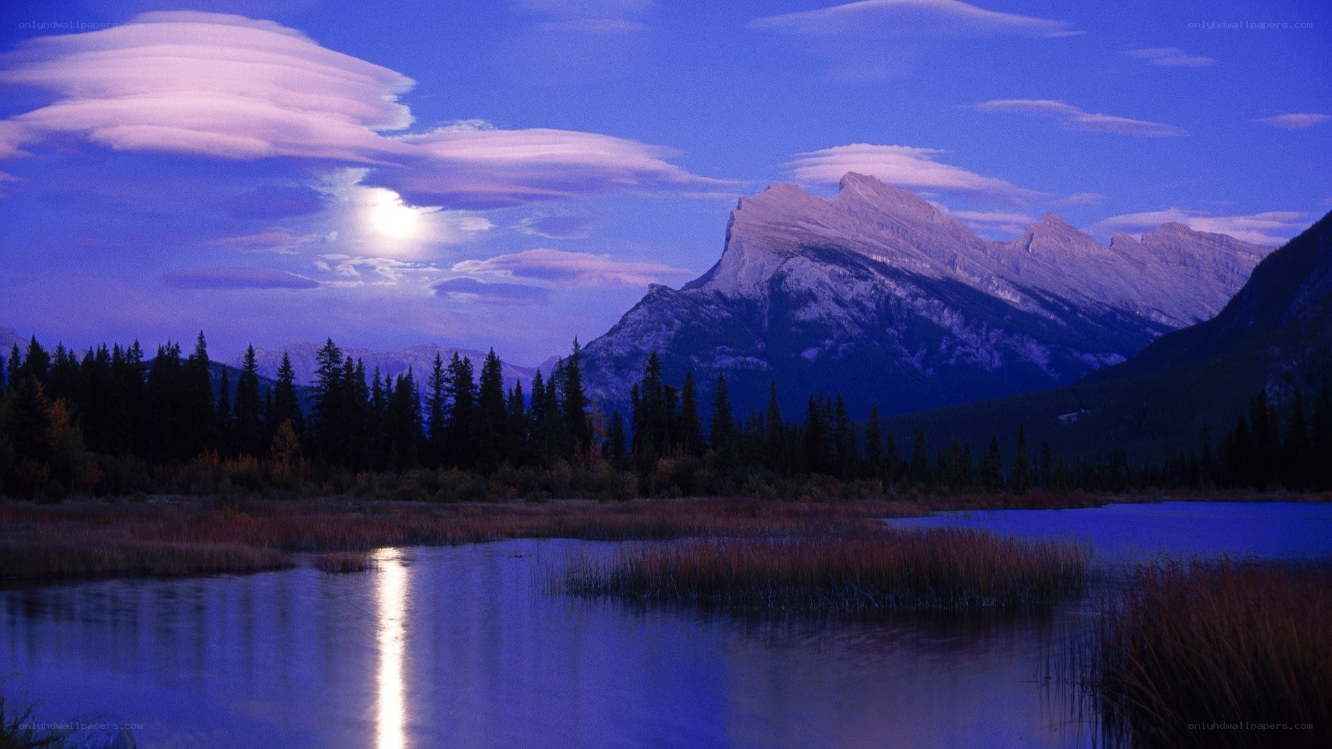 Moonlit mountain lake at dusk