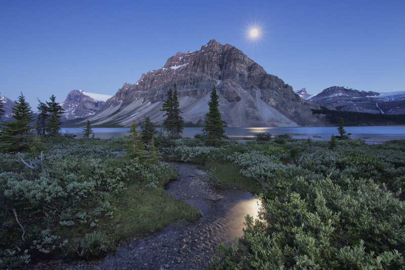 Moonlit mountain lake at dusk