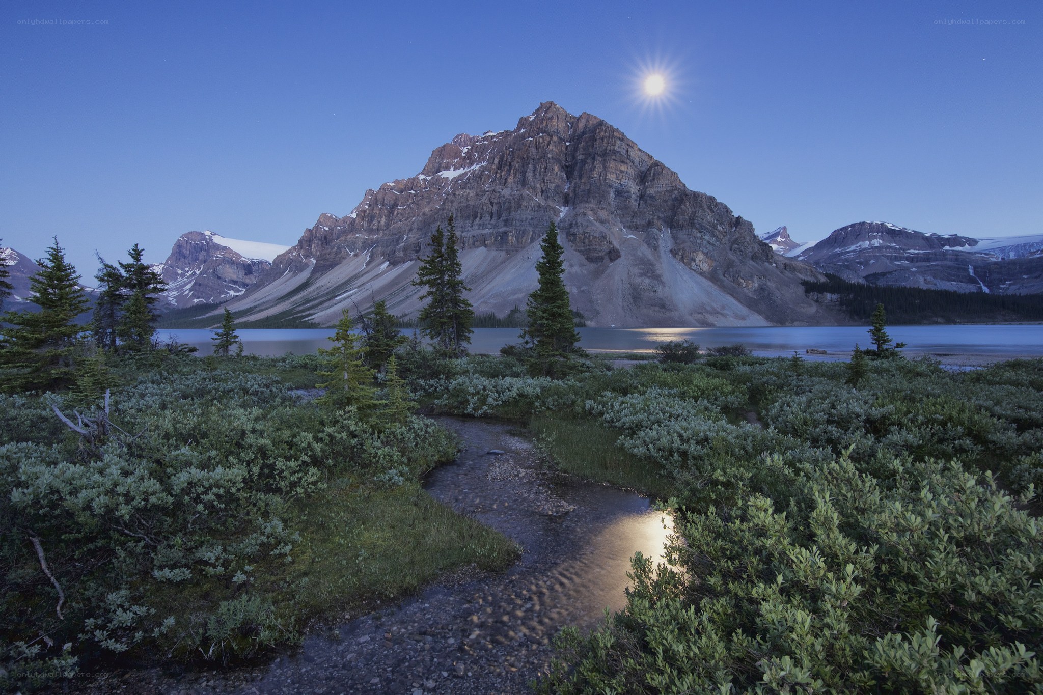 Moonlit mountain lake at dusk