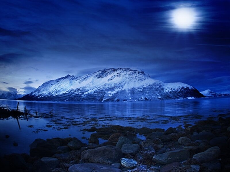Moonlit mountain lake at night
