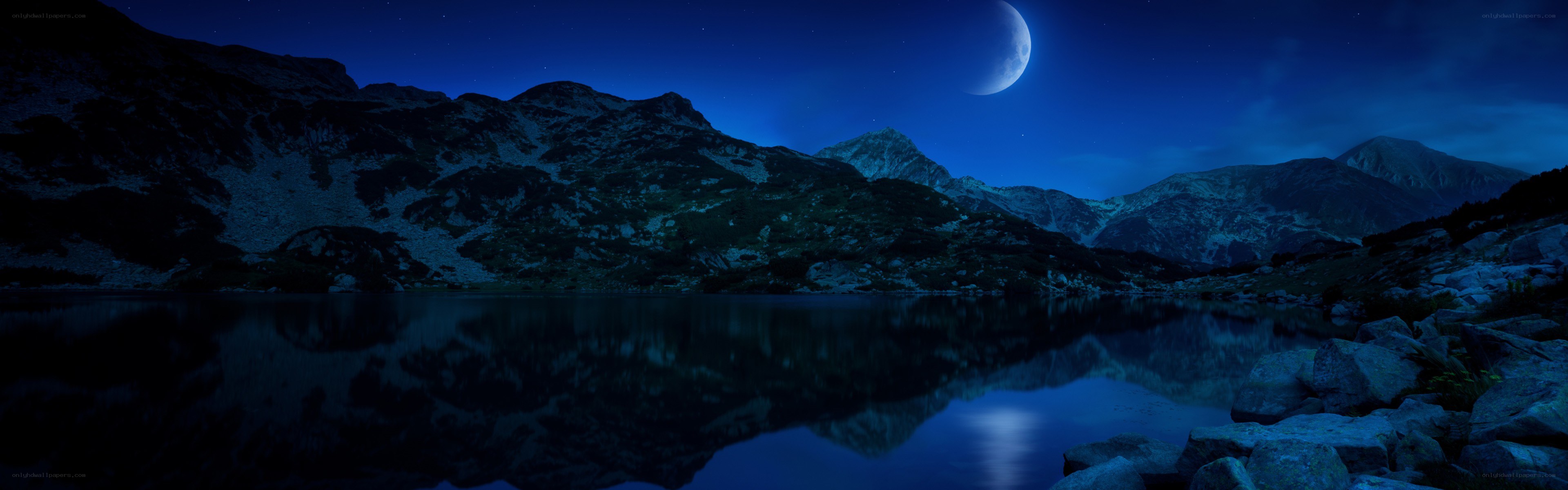 Moonlit mountain lake at night