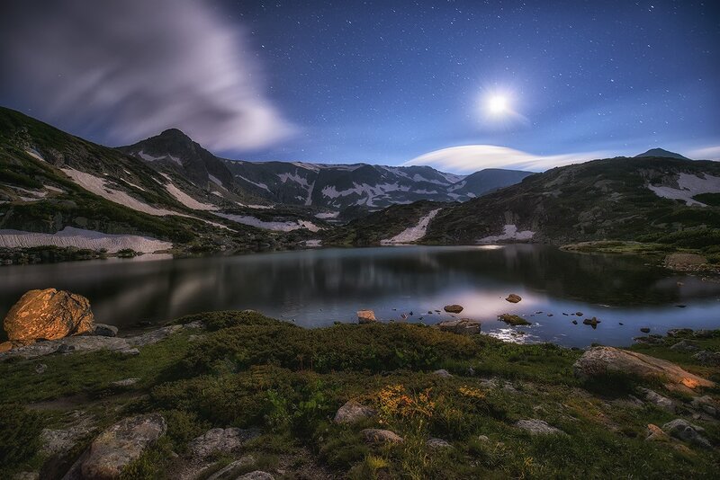 Moonlit mountain lake at night