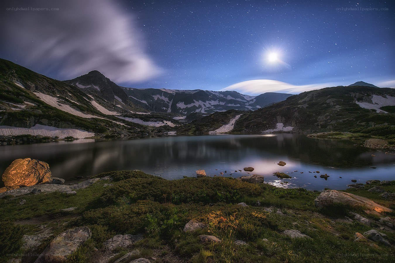 Moonlit mountain lake at night