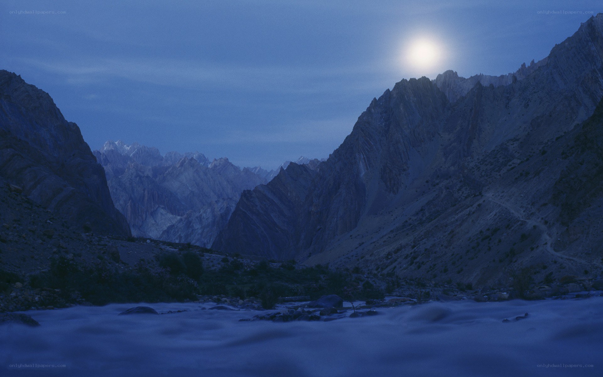 Moonlit mountain valley at dusk