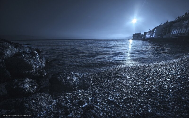 Moonlit pebble beach at night