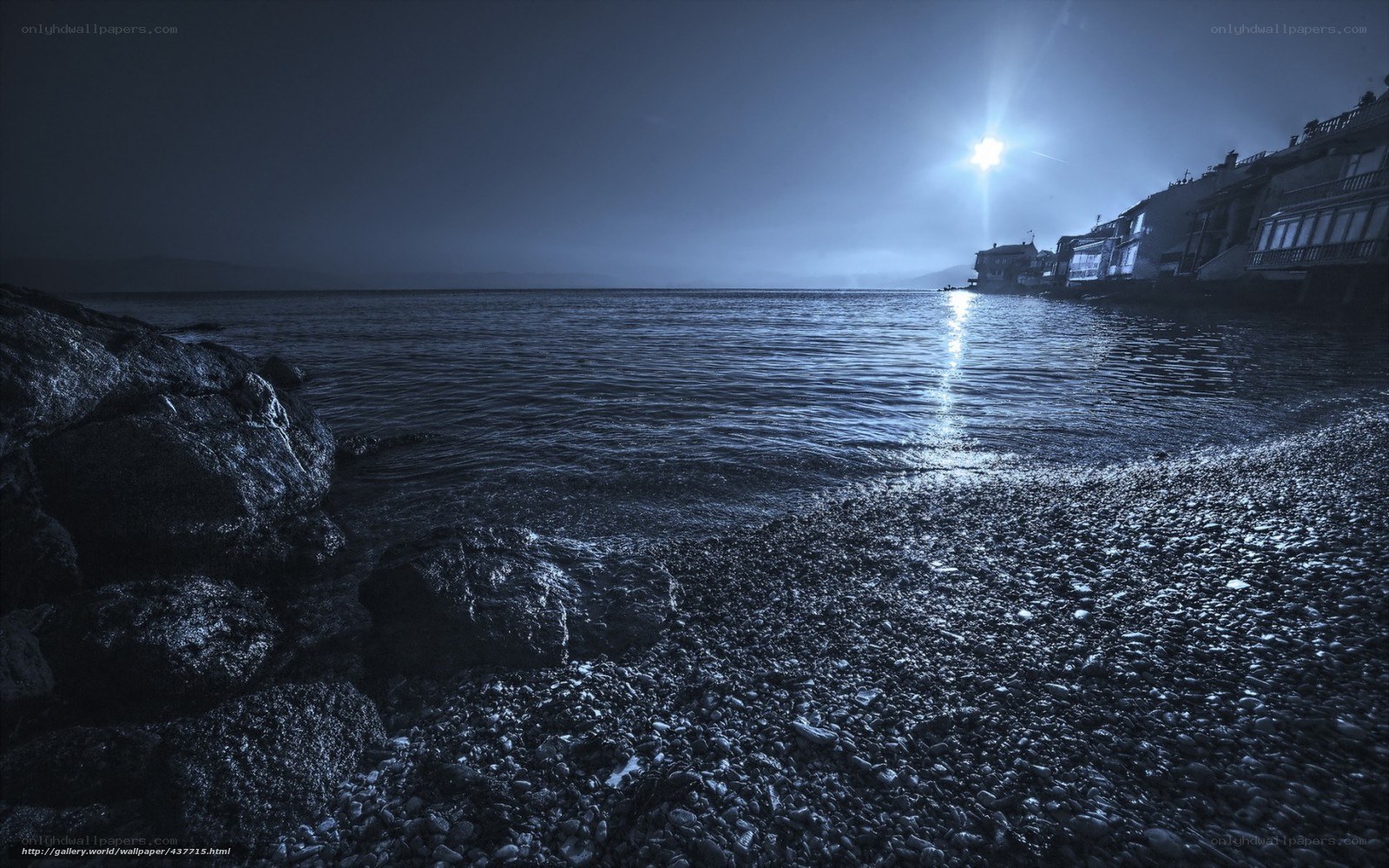 Moonlit pebble beach at night